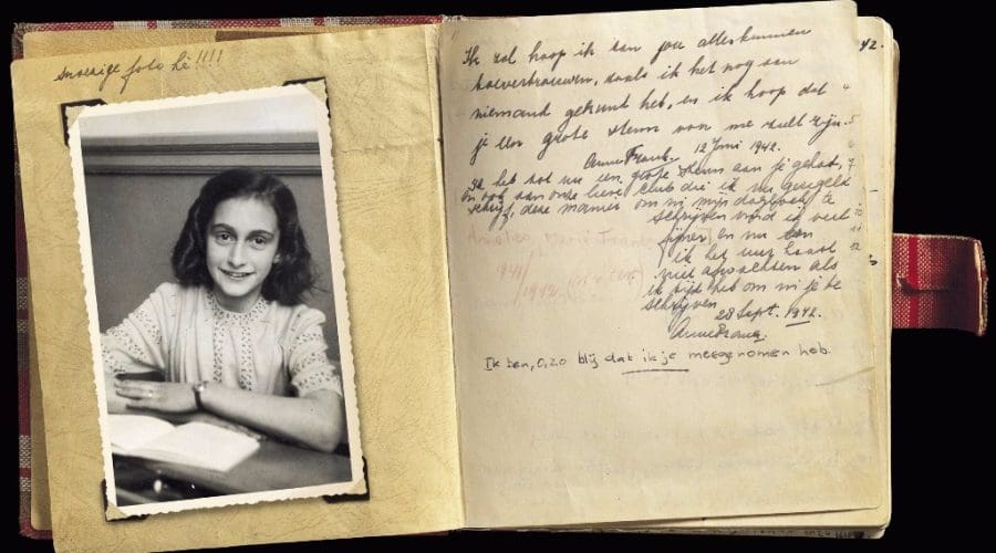 An open diary with a black-and-white photo of Anne Frank on the left page and handwritten Dutch text on the right, reminiscent of memories found along Anne Frank’s Amsterdam Tour. An open diary with a black-and-white photo of Anne Frank on the left page and handwritten Dutch text on the right, reminiscent of memories found along Anne Frank's Amsterdam Tour.