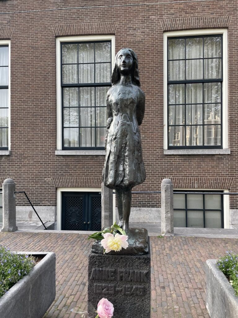 Anne Frank statue with peonies