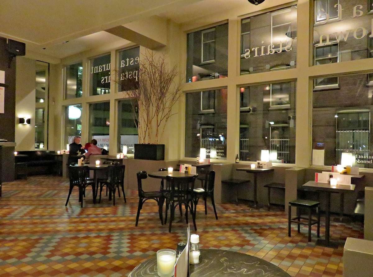 The tall windows and reading tables inside Cafe de Jaren on the Nieuwe Doelenstraat