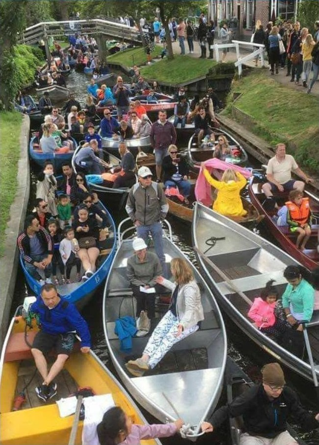A Giethoorn canal packed with tourist boats on a busy summer day