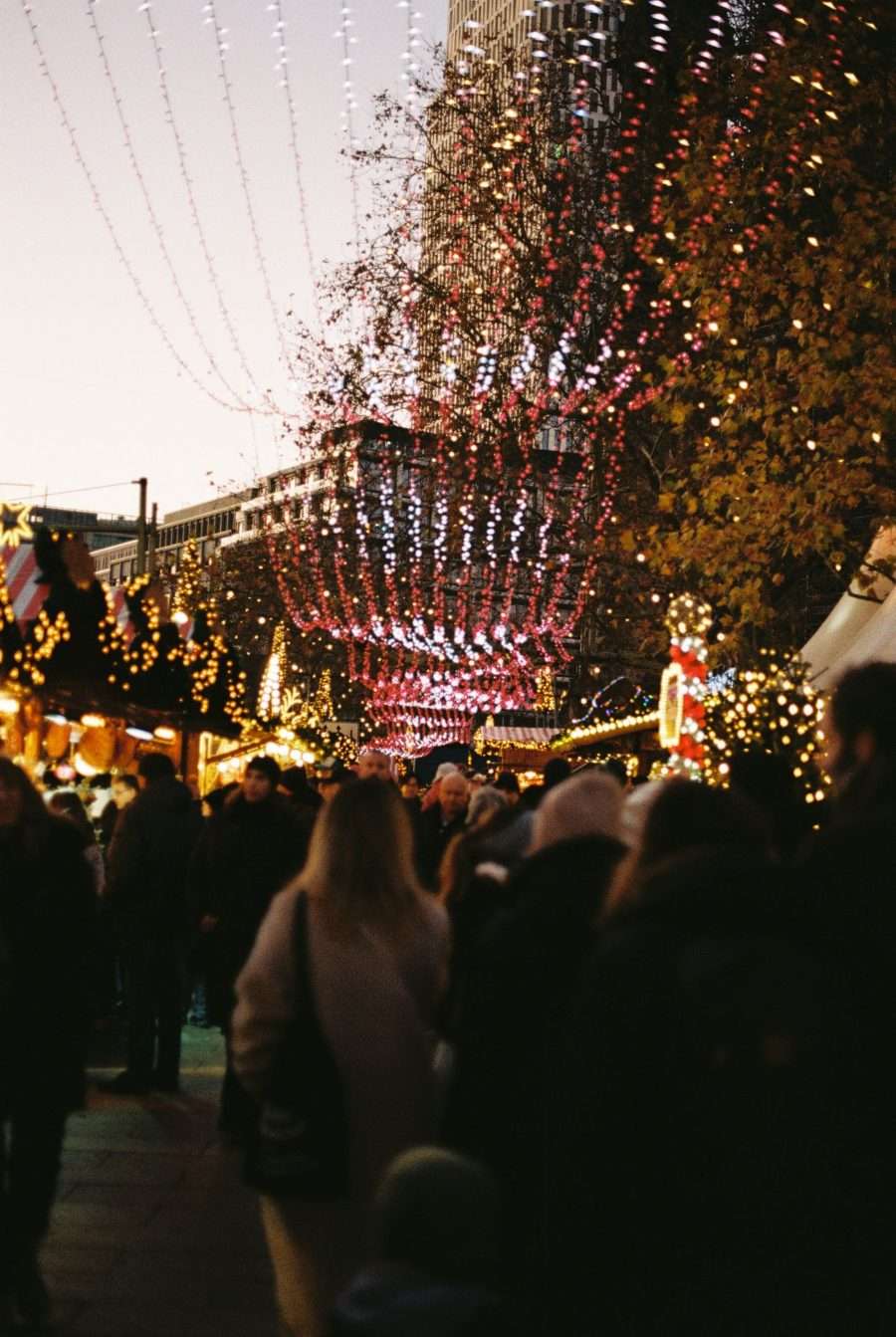 Fairground lights above a Christmas market crowd